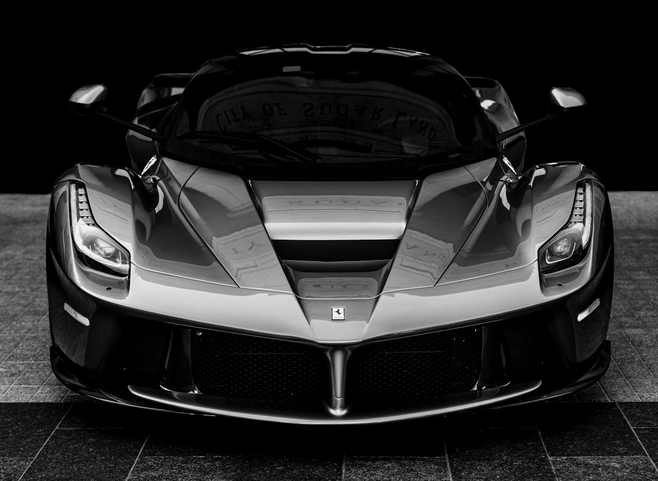 Monochrome close-up of a luxury sports car showcasing design and power.